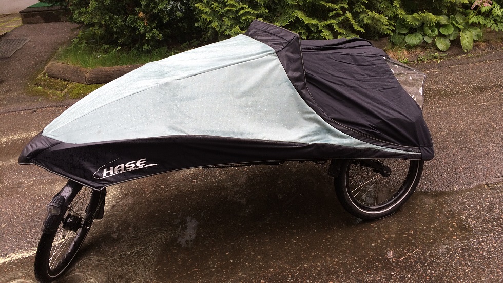 Pyöräilijää sateelta suojaava Hase Rain poncho kiinnitettynä tuulisuojaan